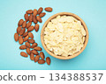 Fresh almond flakes and nuts in bowl on blue background 134388537