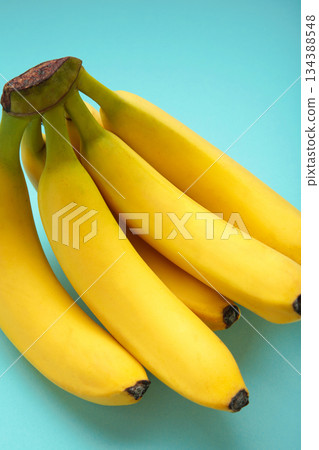 Bunch of bananas on mint background. Top view. Vertical photo Bunch of bananas on mint background. Top view. Vertical photo 134388548