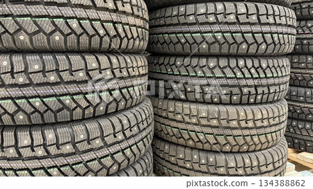 Tires stacked in rows with detailed tread pattern, suitable for automotive industry background Tires stacked in rows with detailed tread pattern, suitable for automotive industry background 134388862