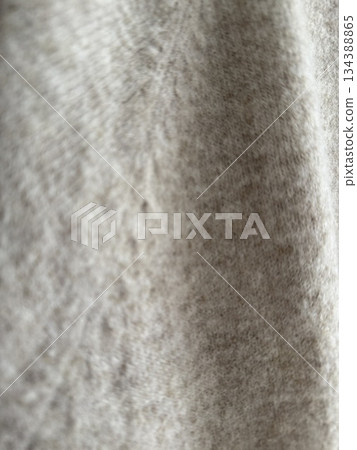 Beige fabric texture with soft folds, suitable for use as a textured background or textile design 134388865