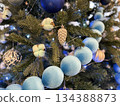 Christmas tree with blue ornaments and pine cones, creating festive holiday background Christmas tree with blue ornaments and pine cones, creating festive holiday background 134388873