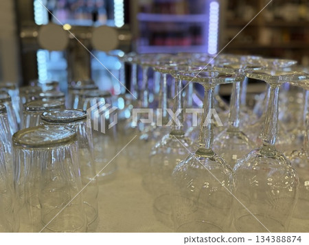 Glassware arrangement with empty wine glasses and beer glasses in bar setting background 134388874