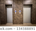 Elevator doors with metallic finish in modern building interior, ideal as architecture background Elevator doors with metallic finish in modern building interior, ideal as architecture background 134388891