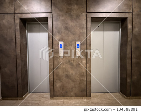 Elevator doors with metallic finish in modern building interior, ideal as architecture background 134388891