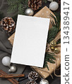 Card on wrapper Christmas present near pine cones, spices and fir twigs, top view. Holiday mockup 134389417