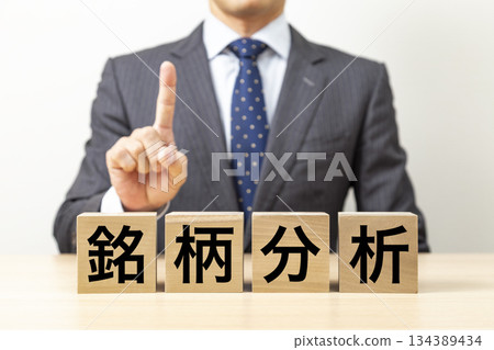 A block with the word "stock analysis" written on it and a businessman A block with the word "stock analysis" written on it and a businessman 134389434