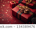 Red gift box with gold bow on top of red background, surrounded by starry background 134389476