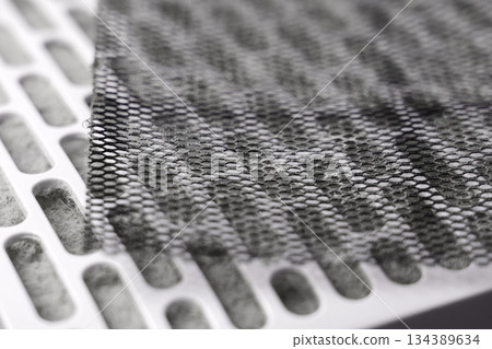 Used industrial air purifier filter parts. Perforated metal mesh and white cartridge clogged with dust 134389634