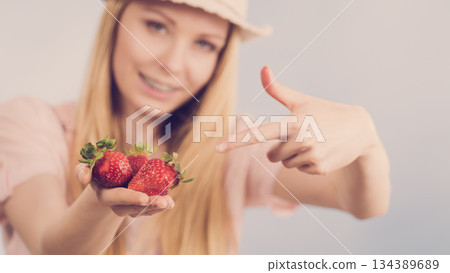 Girl showing fresh strawberries Girl showing fresh strawberries 134389689