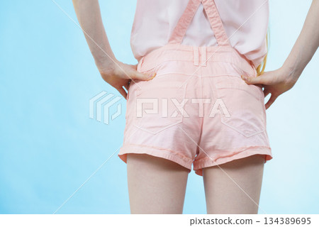 Woman in dungarees back view Woman in dungarees back view 134389695
