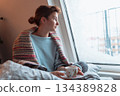 young woman warms up with hot tea in winter weather at home 134389828