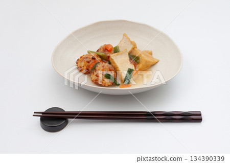 Deep-fried tofu and chicken meatballs simmered in thick sauce on a white background Deep-fried tofu and chicken meatballs simmered in thick sauce on a white background 134390339