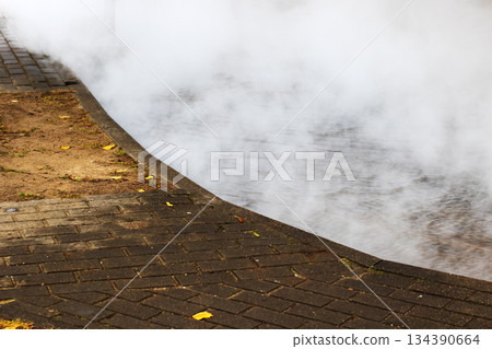 Morning haze engulfs wet urban pathways, Gentle fog rolls over moist city walkways at dawn 134390664