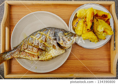 Baked Dorado Fish with Roasted Potatoes on Plate Baked Dorado Fish with Roasted Potatoes on Plate 134390800