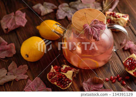 Autumn Beverage: Pomegranate Tea with Lemon and Ginger on Rustic Table 134391129