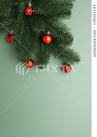 Red Christmas Ornaments Hanging on Pine Branches over Muted Green Background Red Christmas Ornaments Hanging on Pine Branches over Muted Green Background 134391145