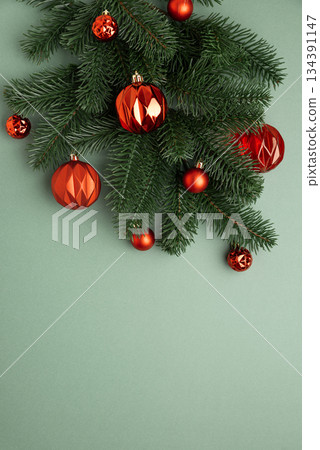 Red Christmas Ornaments Hanging on Pine Branches over Muted Green Background Red Christmas Ornaments Hanging on Pine Branches over Muted Green Background 134391147