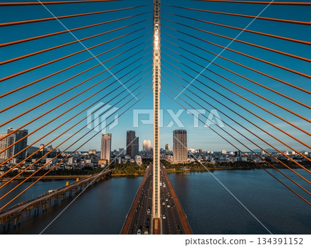 Symmetric modern cable-stayed bridge over Han River in Da Nang, Contemporary urban span connecting city skyline across Vietnamese waterway 134391152