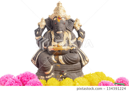 Ganesha statue with gold accents surrounded by bright marigold garlands for spiritual and cultural decoration. 134391224