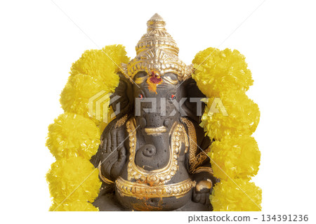 Ganesha idol decoration with gold colored coating and yellow marigold garland for Hindu rituals 134391236
