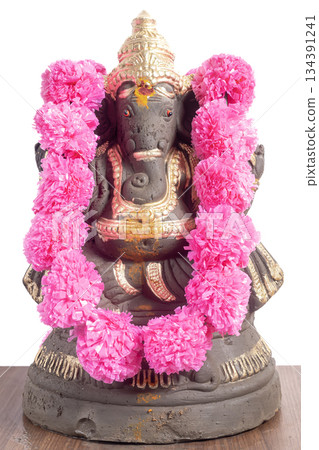 Ganesha idol adorned with pink flower garland for Ganesha Chaturthi festivals. Ganesha idol adorned with pink flower garland for Ganesha Chaturthi festivals. 134391241