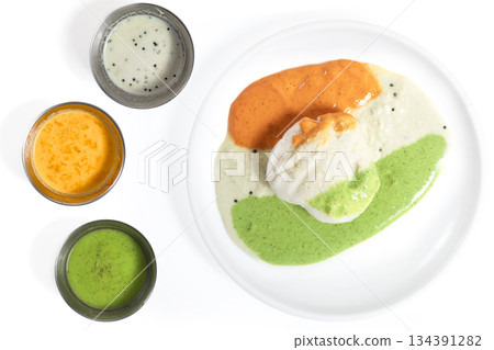 Three varieties of chutney with idli on a white plate, South Indian food Three varieties of chutney with idli on a white plate, South Indian food 134391282