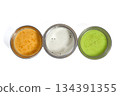 South indian trio of red, coconut, and green chutneys served in stainless steel bowls on white background 134391355
