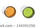 Spicy red chutney and green chutney served in stainless steel bowls on white background. 134391356