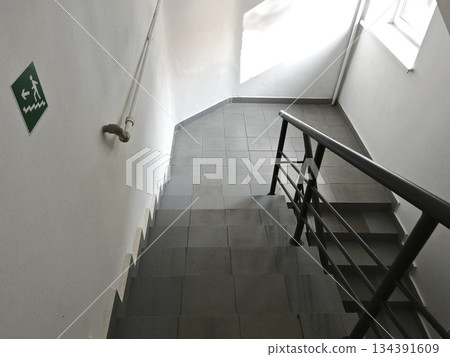 Stairs inside the building. empty stairs in the office. Staircase with emergency exit sign. Stairs inside the building. empty stairs in the office. Staircase with emergency exit sign. 134391609