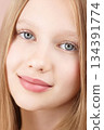 Face. Portrait of a funny smiling young girl. Blonde Caucasian girl with blue eyes isolated on pink background. Advertising beauty concept skin care for teenagers. Haircare. Self care Gen Alpha 134391774