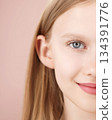 Half face. Portrait of a funny smiling blonde young girl posing in studio pink background. Advertising beauty Skincare products for teens or kids. Haircare. Self care Generation Alpha. Copy space 134391776