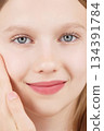 Close-up portrait beautiful Caucasian girl posing look at camera on studio, charming smile, natural beauty Gen Alpha. Face. Adverts for skincare cosmetics for teengers or children. Self care treatment 134391784