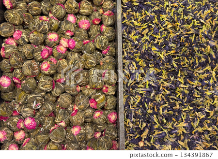 Blooming green tea balls with embedded flowers arranged beside loose petals in Istanbul bazaar. Artisanal tea craftsmanship, visual ritual, and botanical infusion culture highlighted through form and Blooming green tea balls with embedded flowers arranged beside loose petals in Istanbul bazaar. Artisanal tea craftsmanship, visual ritual, and botanical infusion culture highlighted through form and 134391867