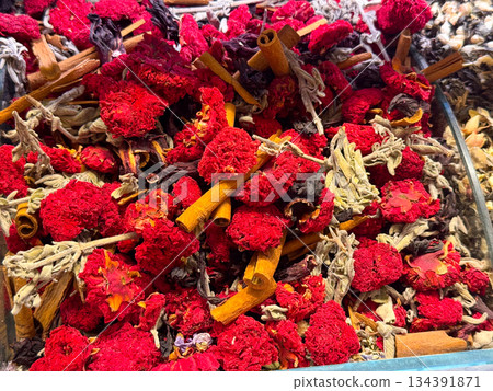 Dried hibiscus flowers mixed with cinnamon sticks and herbs creating a rich herbal composition in Istanbul bazaar. Botanical tea culture, aromatic infusions, and natural wellness traditions expressed Dried hibiscus flowers mixed with cinnamon sticks and herbs creating a rich herbal composition in Istanbul bazaar. Botanical tea culture, aromatic infusions, and natural wellness traditions expressed 134391871