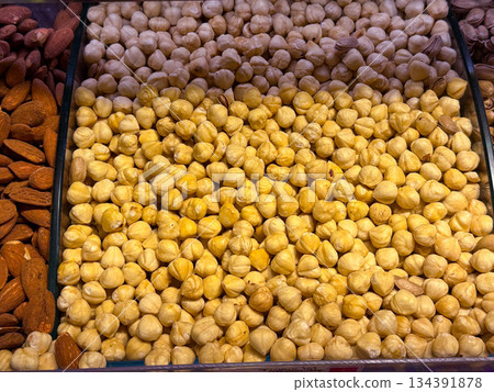 Peeled hazelnuts densely packed in a market display in Istanbul bazaar. Natural nut ingredients, wholesome nutrition, and everyday food abundance emphasized through repetition and form. Peeled hazelnuts densely packed in a market display in Istanbul bazaar. Natural nut ingredients, wholesome nutrition, and everyday food abundance emphasized through repetition and form. 134391878