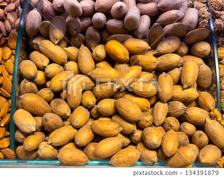 Whole almonds in shells filling a display tray in Istanbul bazaar. Natural nuts, raw ingredients, and nutrient dense food culture expressed through texture, abundance, and agricultural simplicity. Whole almonds in shells filling a display tray in Istanbul bazaar. Natural nuts, raw ingredients, and nutrient dense food culture expressed through texture, abundance, and agricultural simplicity. 134391879