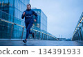 Athletic woman jogging modern city street 134391933
