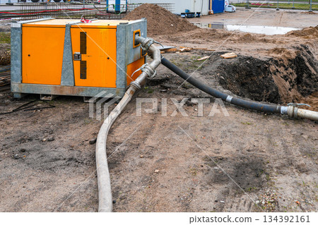 Construction site dewatering pump system removing groundwater from excavation area 134392161