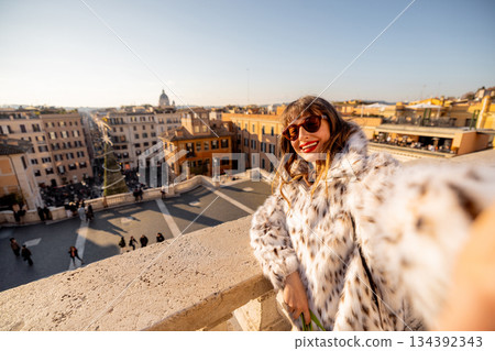 Smiling woman celebrating New Year 2025 with panoramic city view in Rome 134392343