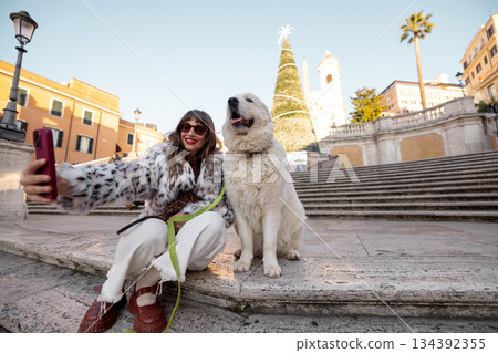 Woman taking a selfie with dog near the Spanish Steps in Rome during holiday season Woman taking a selfie with dog near the Spanish Steps in Rome during holiday season 134392355