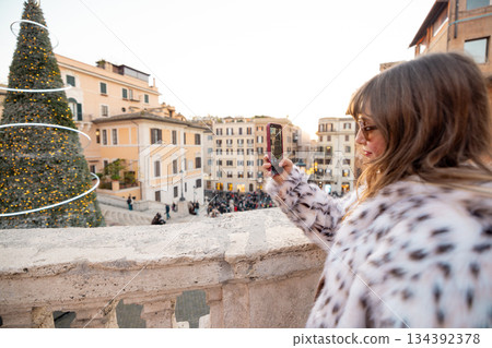 Woman photographing festive city view near the Spanish Steps in Rome 134392378
