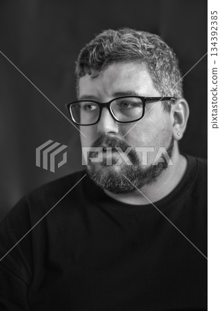 Portrait of young Caucasian man with glasses, beard on black. Portrait of young Caucasian man with glasses, beard on black. 134392385