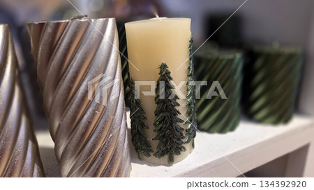 Festive holiday candles with Christmas tree designs for seasonal decoration 134392920