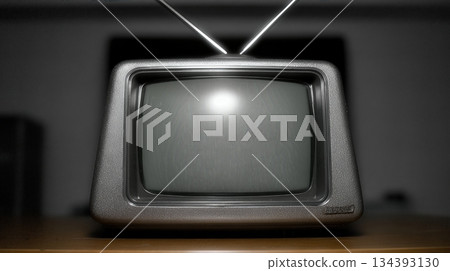 Retro Tv Sits on a Wooden Table With High Contrast Lighting in a Dim Room During the Evening Hours Retro Tv Sits on a Wooden Table With High Contrast Lighting in a Dim Room During the Evening Hours 134393130