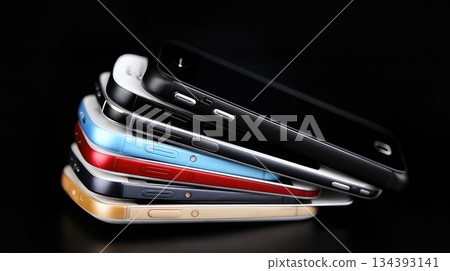 Various Alternative Mobile Phones Stacked Together in Colorful Cases on a Dark Background Various Alternative Mobile Phones Stacked Together in Colorful Cases on a Dark Background 134393141