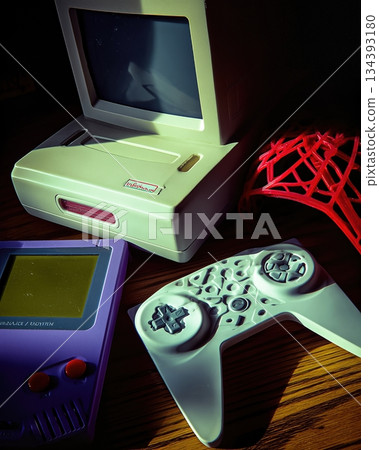 Nostalgic Gaming and Tech Items From the Past on a Wooden Table in Soft Light Nostalgic Gaming and Tech Items From the Past on a Wooden Table in Soft Light 134393180