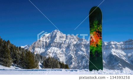 Snowboard Stands Upright in Fresh Powder Against a Backdrop of Majestic Mountains on a Sunny Day Snowboard Stands Upright in Fresh Powder Against a Backdrop of Majestic Mountains on a Sunny Day 134393258