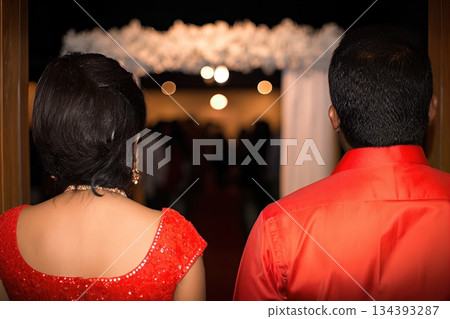 Couple Stands Back to Back at an Indian Wedding Ceremony in a Decorated Venue Couple Stands Back to Back at an Indian Wedding Ceremony in a Decorated Venue 134393287