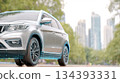 Closeup of a Shiny New Car Parked Against an Urban Landscape With Tall Buildings 134393331