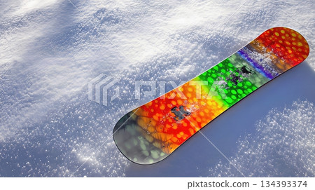 Snowboard Resting on Pristine Snow Slope With Vibrant Colors Under Bright Sunlight Snowboard Resting on Pristine Snow Slope With Vibrant Colors Under Bright Sunlight 134393374